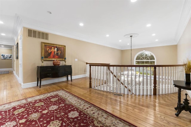 hallway featuring an upstairs landing, wood-type flooring, ornamental molding, baseboards, and recessed lighting