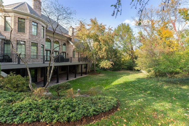 view of green lawn with a wooden deck