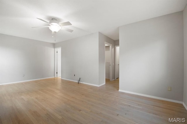 empty room with a ceiling fan, light wood-style floors, and baseboards