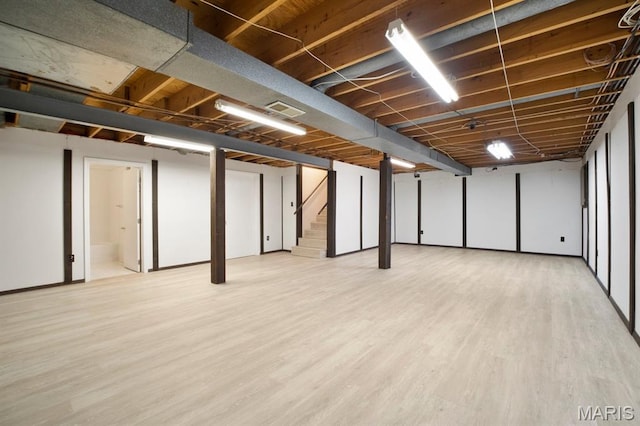 finished below grade area featuring wood finished floors and stairway