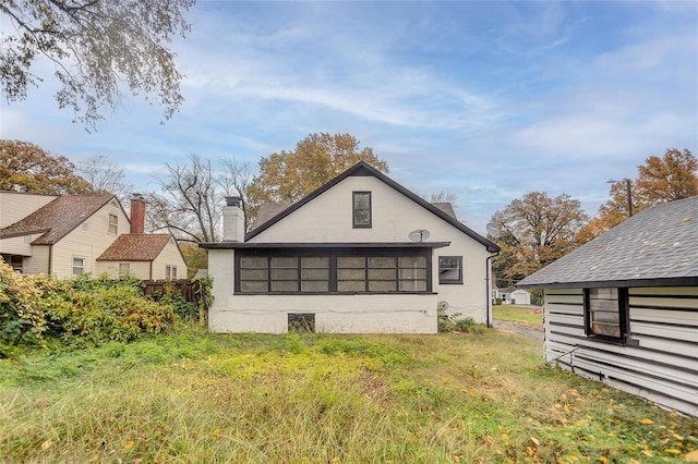 back of property featuring a chimney and fence