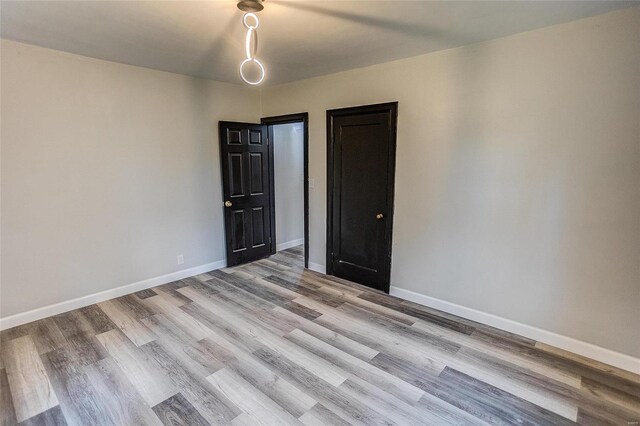 spare room with light wood-style floors and baseboards