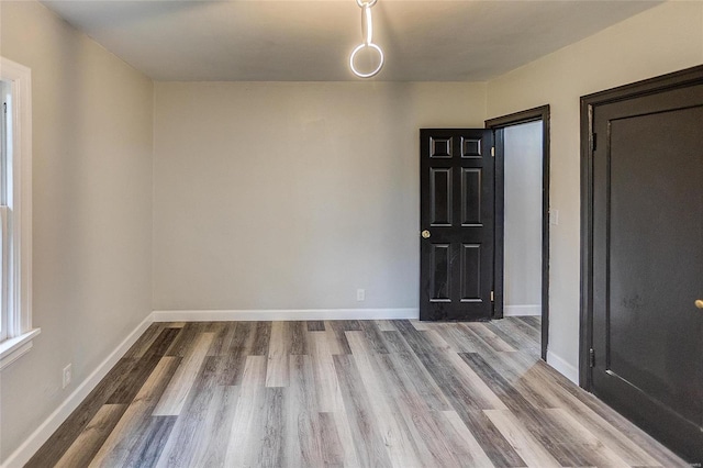 empty room featuring wood finished floors and baseboards