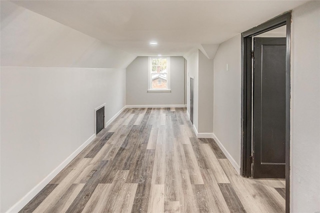 bonus room with wood finished floors, baseboards, and lofted ceiling