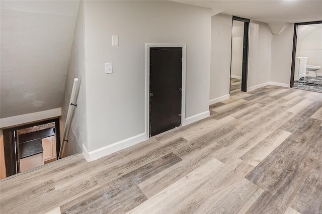 unfurnished living room with wood finished floors and baseboards