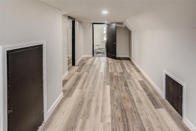 additional living space featuring light wood finished floors and baseboards