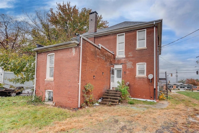 124 Carlyle Ave, Belleville, IL 62220 - back of property featuring brick siding, a chimney, a yard, and entry steps