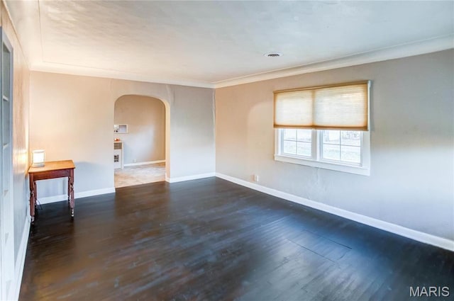 219 Highland St, Carrollton, IL 62016 - empty room with arched walkways, wood finished floors, baseboards, and ornamental molding