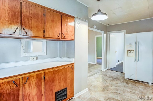 219 Highland St, Carrollton, IL 62016 - kitchen with white refrigerator with ice dispenser, brown cabinets, light countertops, hanging light fixtures, and baseboards