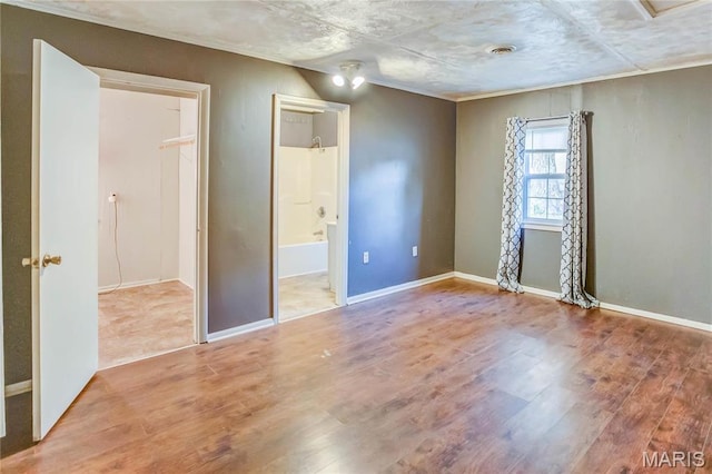 219 Highland St, Carrollton, IL 62016 - unfurnished bedroom with wood finished floors, baseboards, and ensuite bath
