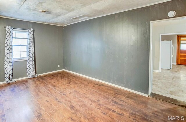 219 Highland St, Carrollton, IL 62016 - empty room with wood finished floors, wooden walls, and a smoke detector