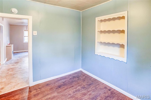 219 Highland St, Carrollton, IL 62016 - empty room featuring built in shelves, wood finished floors, baseboards, and a smoke detector