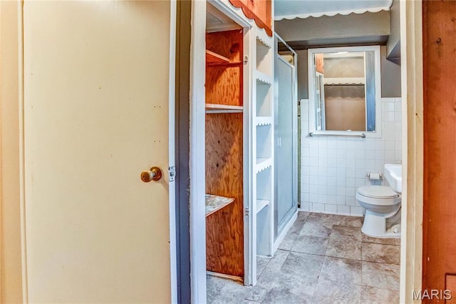 219 Highland St, Carrollton, IL 62016 - bathroom with tile walls, a stall shower, and toilet