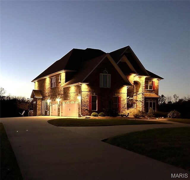13185 Jenna Ln, Rolla, MO 65401 - view of front facade featuring stone siding, an attached garage, and curved driveway
