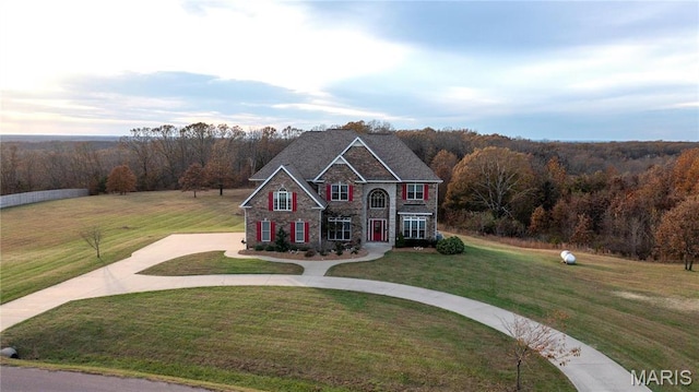 13185 Jenna Ln, Rolla, MO 65401 - view of front of property with curved driveway, a front yard, a forest view, and stone siding