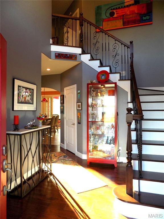13185 Jenna Ln, Rolla, MO 65401 - stairs with wood finished floors, arched walkways, a high ceiling, and baseboards