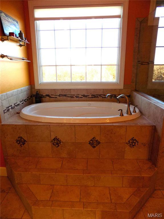 13185 Jenna Ln, Rolla, MO 65401 - bathroom with healthy amount of natural light, a garden tub, and tile patterned flooring