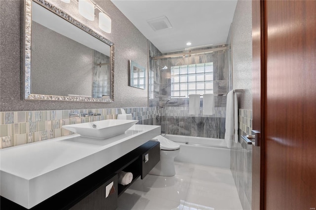 full bathroom featuring toilet, enclosed tub / shower combo, tile walls, vanity, and tile patterned floors