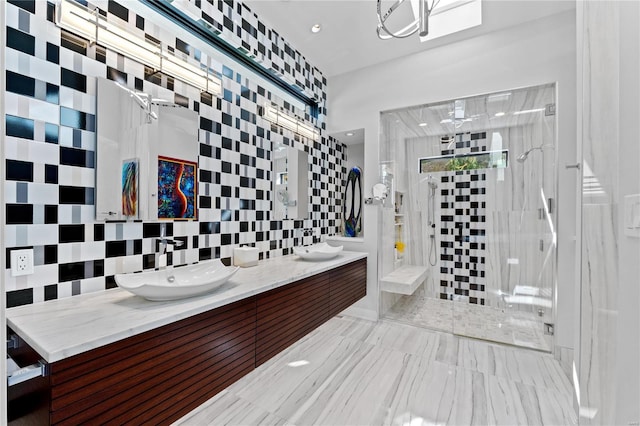 bathroom with a walk in shower, decorative backsplash, double vanity, and tile walls