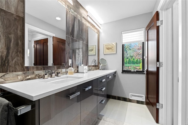 full bath featuring decorative backsplash, double vanity, and baseboards