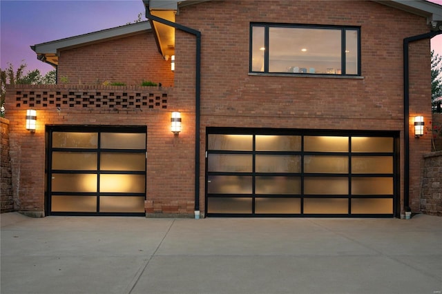 view of front facade with driveway, a garage, and brick siding