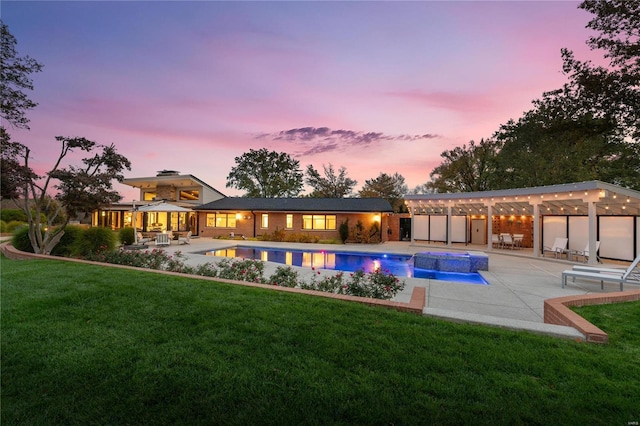 pool at dusk with a patio area, a lawn, and an outdoor pool