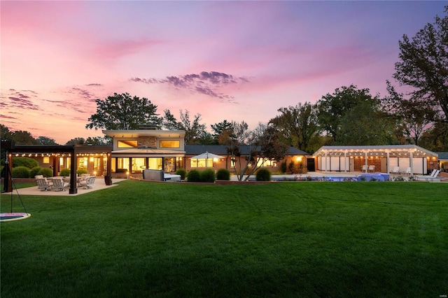 back of property at dusk featuring a yard and a patio
