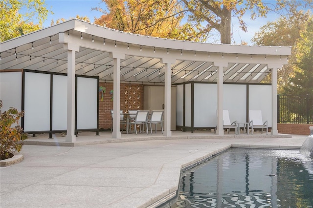 rear view of house with an outdoor pool, fence, and a patio