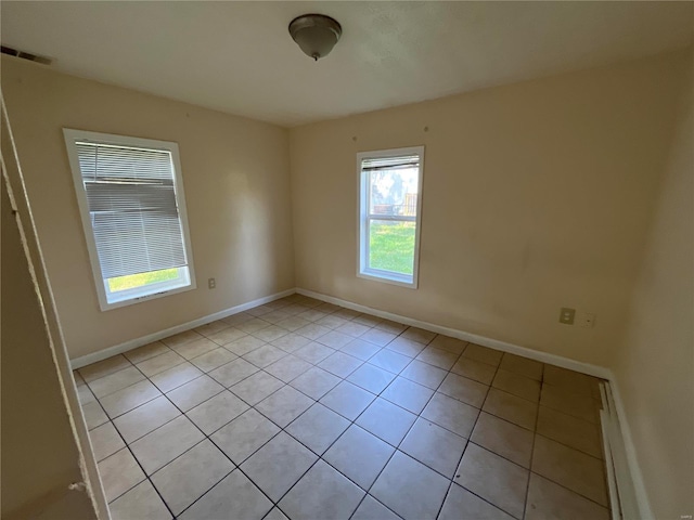 unfurnished room featuring light tile patterned floors and baseboards