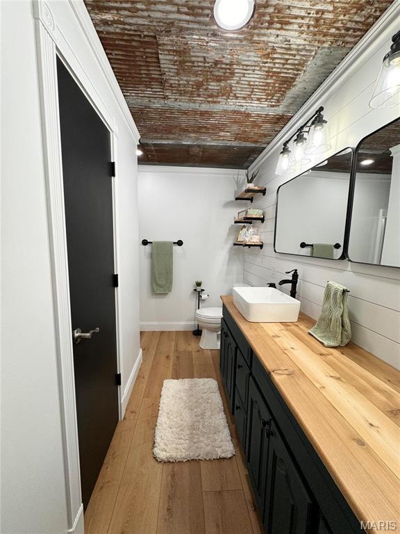 62812 Brown Ests, Hannibal, MO 63401 - bathroom featuring baseboards, hardwood / wood-style flooring, vanity, toilet, and brick ceiling