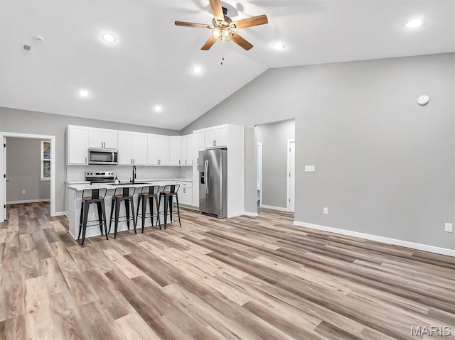 60 Cedar Brook Dr, Pacific, MO 63069 - kitchen featuring appliances with stainless steel finishes, a kitchen bar, ceiling fan, light countertops, and a center island with sink
