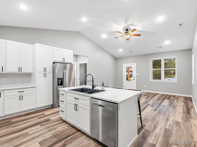 60 Cedar Brook Dr, Pacific, MO 63069 - kitchen featuring stainless steel appliances, ceiling fan, vaulted ceiling, a kitchen island with sink, and backsplash