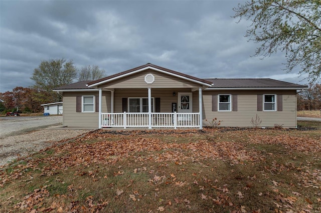 ranch-style home featuring covered porch and metal roof