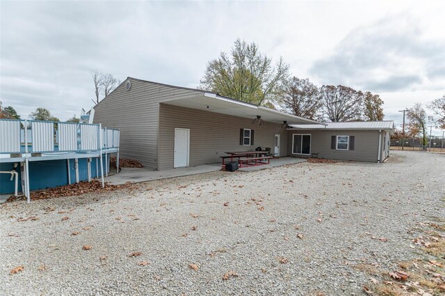 back of house featuring a patio area and a carport