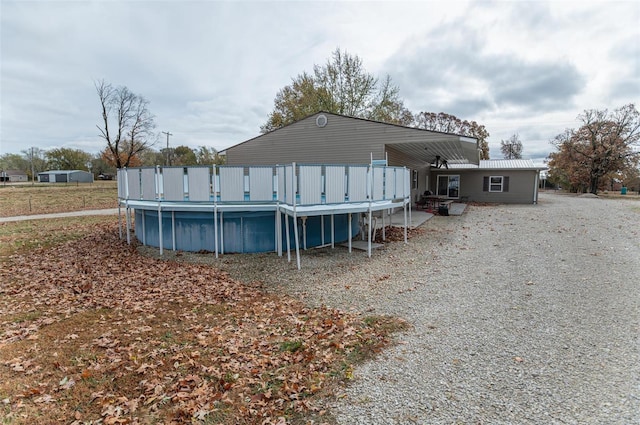rear view of house featuring an outdoor pool