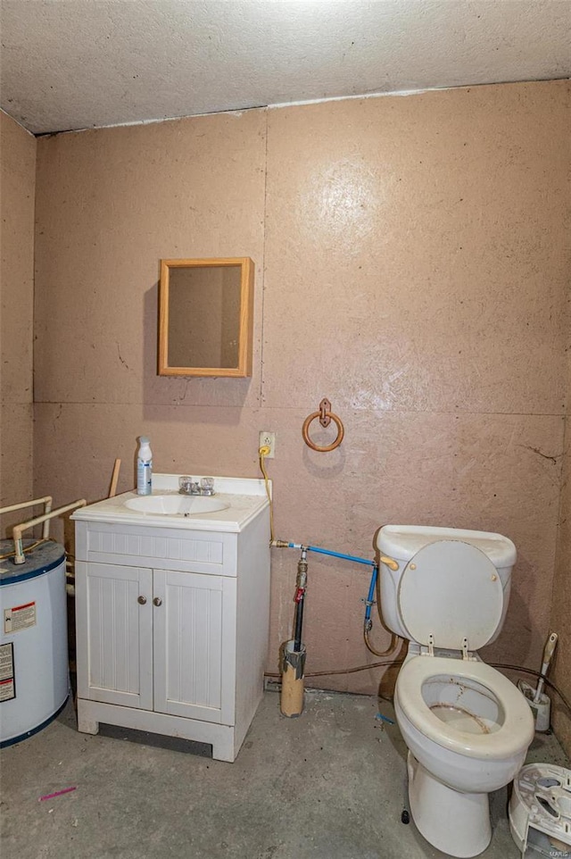 bathroom featuring concrete floors, electric water heater, vanity, and toilet