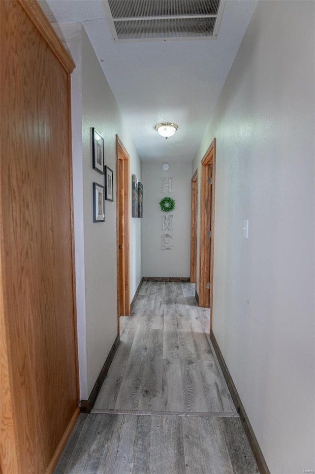 hallway with light wood-style flooring and baseboards