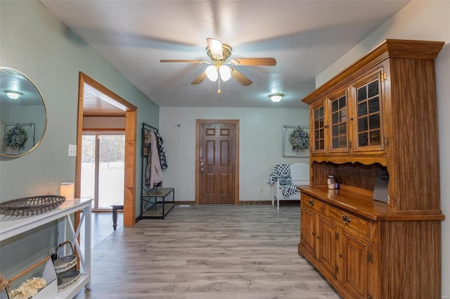 foyer featuring ceiling fan, light wood finished floors, and baseboards