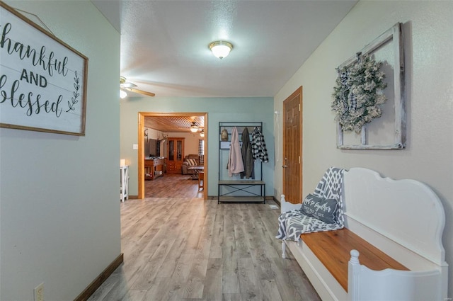 corridor featuring wood finished floors and baseboards