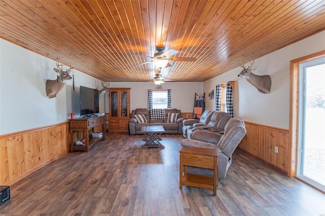 living room featuring wood walls, a wainscoted wall, wood finished floors, wood ceiling, and ceiling fan