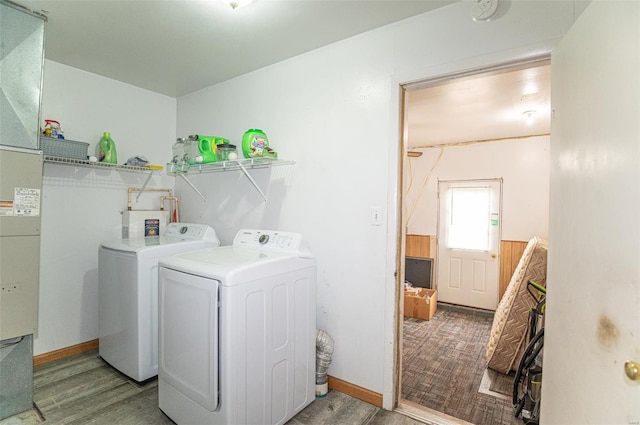 laundry room with washing machine and clothes dryer and wood finished floors