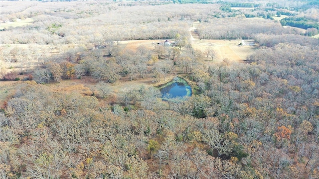 aerial view of property's location with a nearby body of water and a heavily wooded area