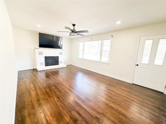 unfurnished living room with ceiling fan, dark wood-style flooring, a fireplace, baseboards, and recessed lighting