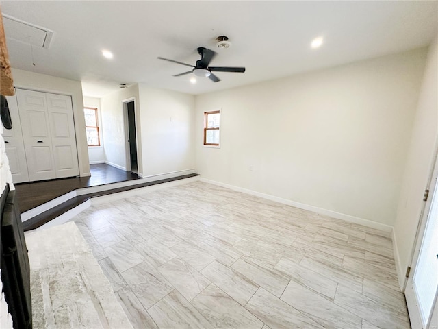 spare room featuring attic access, healthy amount of natural light, a ceiling fan, baseboards, and recessed lighting