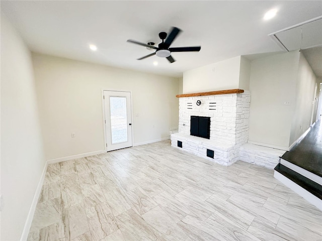 unfurnished living room featuring attic access, ceiling fan, a fireplace with raised hearth, baseboards, and recessed lighting