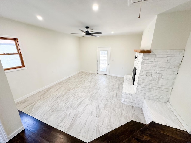 unfurnished living room with plenty of natural light, a ceiling fan, light wood-style floors, attic access, and recessed lighting