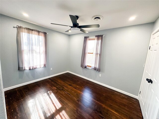 spare room featuring a ceiling fan, wood finished floors, and baseboards