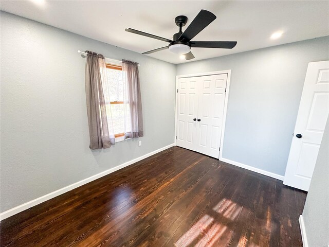 unfurnished bedroom with wood finished floors, baseboards, ceiling fan, and a closet