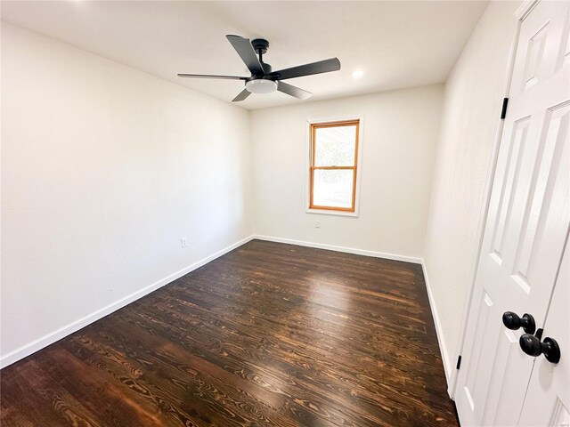 unfurnished room with ceiling fan, dark wood-type flooring, and baseboards