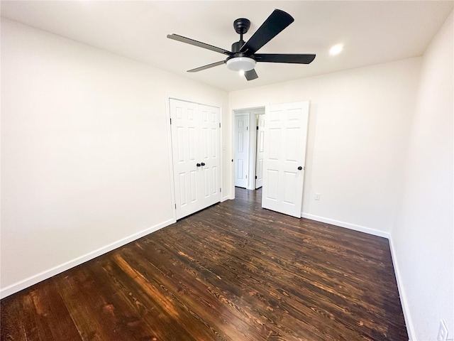 unfurnished bedroom with baseboards, dark wood finished floors, and a ceiling fan